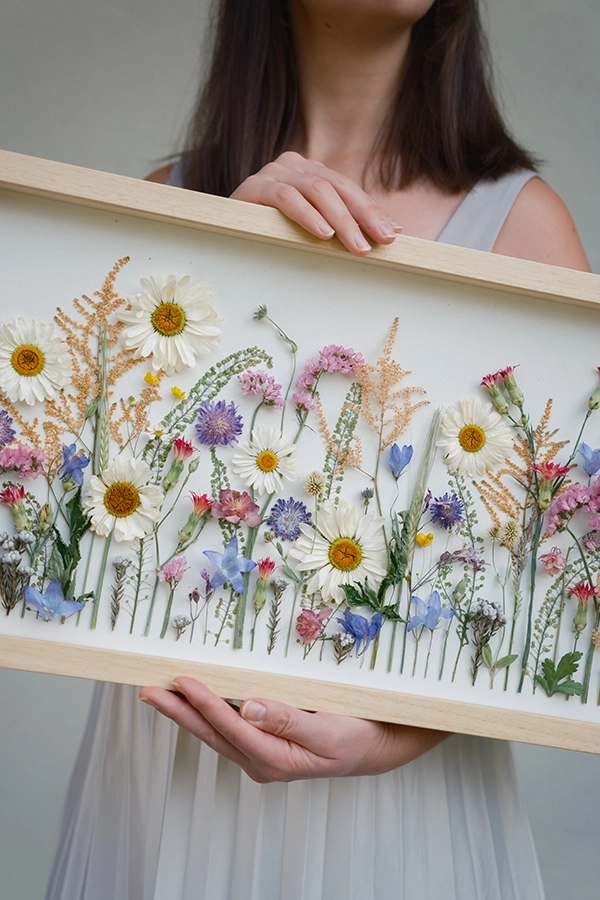 Delovni prostor z raztresenimi cvetnimi lističi, škarjami in različnimi vrstami rož, vključno z vrtnicami in liziantusom.