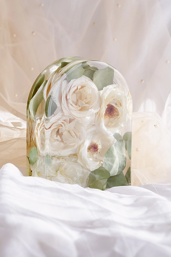 Prstan iz nerjavečega jekla z delčki cvetov, ujetimi v epoksi smoli.