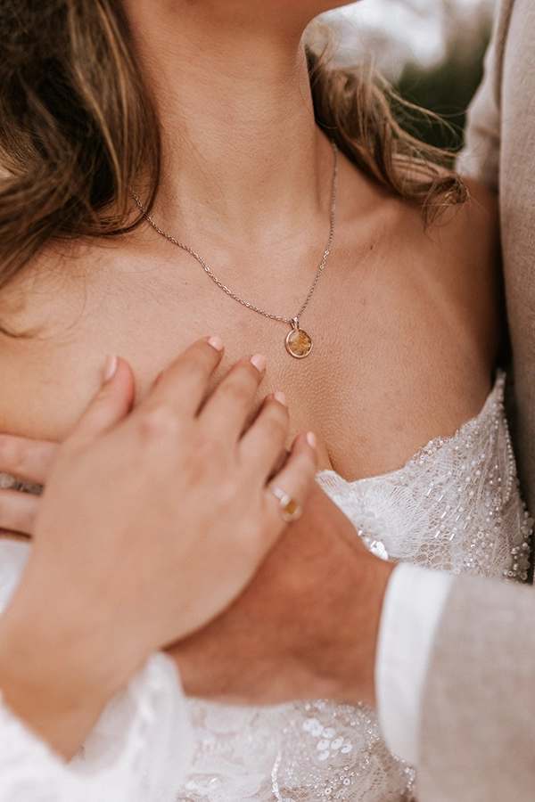 Podstavek šestkotne oblike iz prozorne epoksi smole, v katero so ujeti delčki posušenih cvetov v modri in rožnati barvi, ter lističi 24-karatnega zlata.